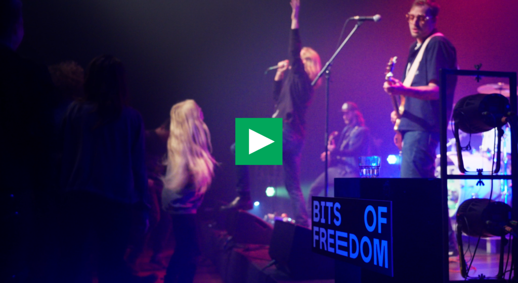 Screenshot van de aftermovie-video met op de achtergrond een band.